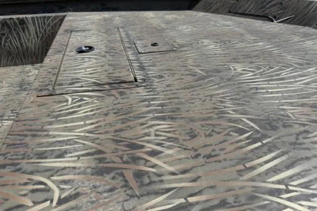 Slide: The Image of 2026 Tracker Grizzly 1860 Utility boat deck with camo pattern and storage compartments. - 5