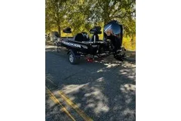 Slide: The Image of 2026 Tracker Pro Team 175 boat parked on a sunny road with trees. - 2