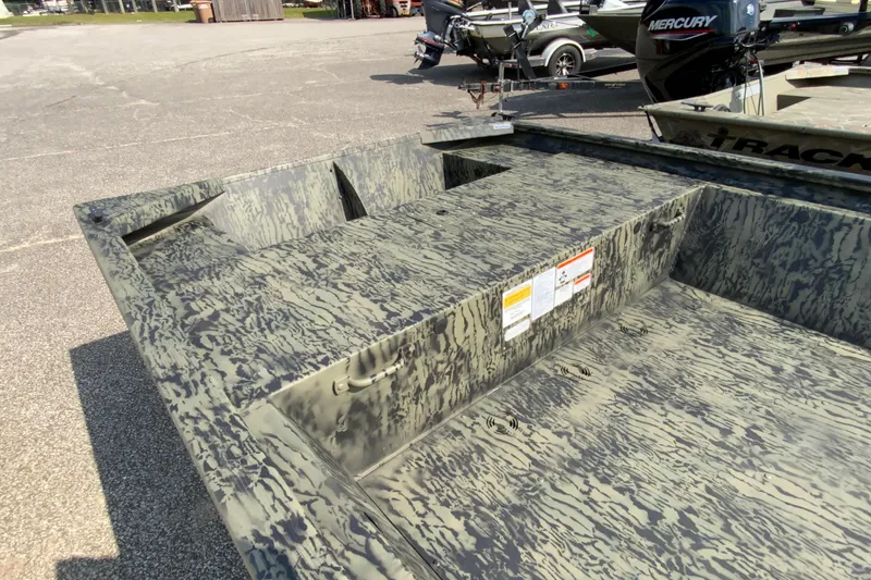 Slide: The Image of 2026 Tracker Grizzly 1648 Utility boat with camouflage pattern, parked outdoors. - 5