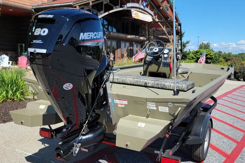 The Image of 2026 Tracker Grizzly 1860 CC boat on trailer, "We Take Trades" sign visible. - 0