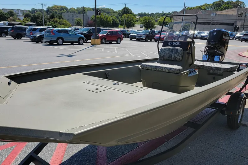 Slide: The Image of 2026 Tracker Grizzly 1860 CC boat interior with steering console in parking lot. - 4