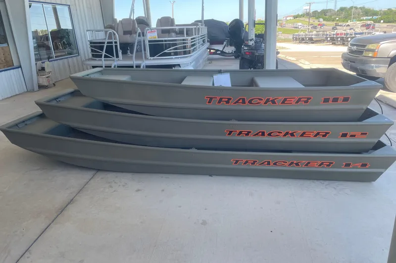 Slide: The Image of Stacked 2026 Tracker Grizzly 10 Jon boats displayed at a dealership. - 4