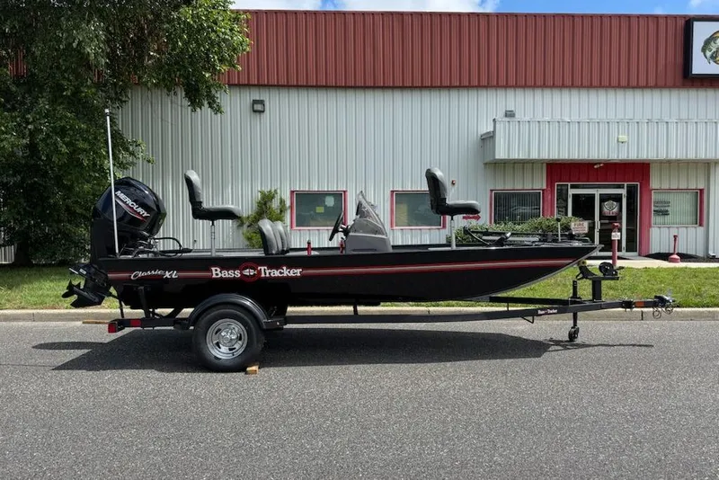 The Image of 2026 Tracker Bass Tracker Classic XL boat on trailer, parked outside a building. - 0