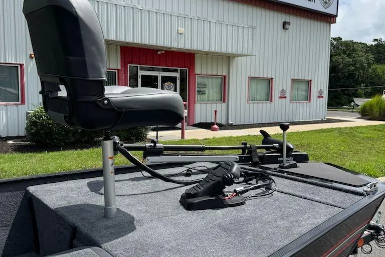 Slide: The Image of 2026 Tracker Bass Tracker Classic XL boat with seat and controls, parked outside a building. - 8