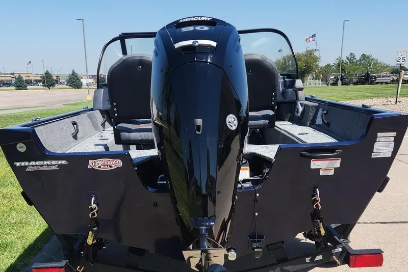 Slide: The Image of 2026 Tracker Pro Guide V-16 WT boat with Mercury engine, parked outdoors. - 9