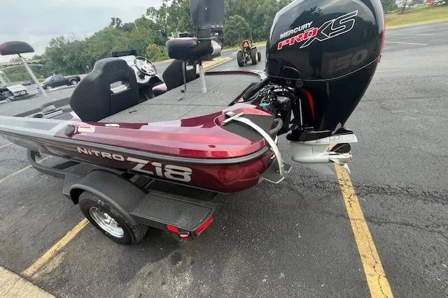 Slide: The Image of 2026 Nitro Z18 Pro boat parked by a lake, featuring sleek design and powerful engine. - 2