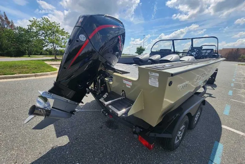 Slide: The Image of 2026 Tracker Targa V-18 Combo boat with powerful outboard motor in a parking lot. - 6
