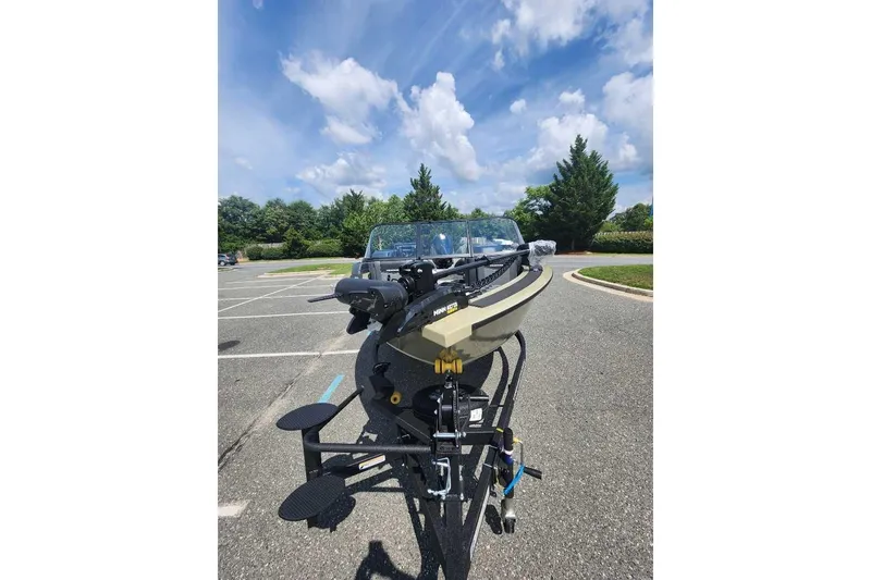 Slide: The Image of 2026 Tracker Targa V-18 Combo boat on trailer in parking lot under blue sky. - 7