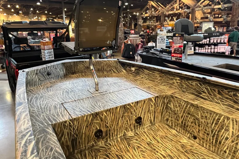 Slide: The Image of 2026 Tracker Grizzly 1650 T Prairie Wings Edition boat with camouflage design in a showroom. - 5
