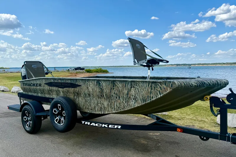 The Image of 2026 Tracker Grizzly 1650 T Prairie Wings Edition boat on trailer by a lake. - 0