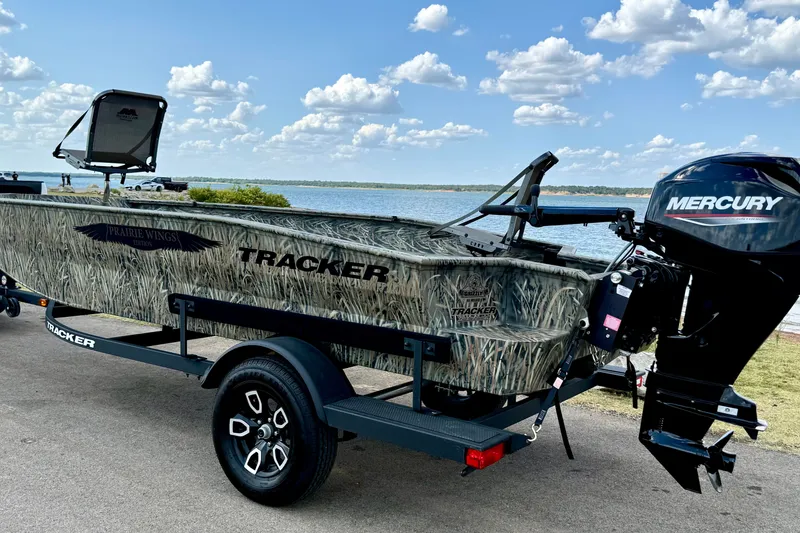 Slide: The Image of 2026 Tracker Grizzly 1650 T Prairie Wings Edition boat with Mercury engine by a lake. - 15