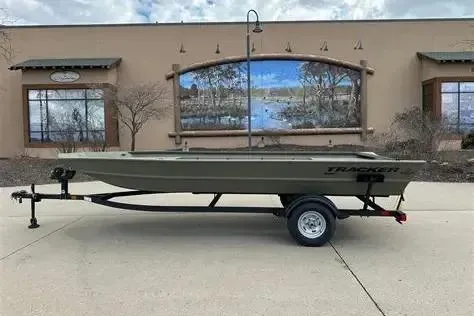 The Image of 2026 Tracker GRIZZLY 1860 Utility boat on trailer, parked outdoors. - 0