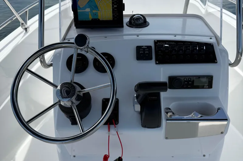 Slide: The Image of 2019 Edgewater 170CC boat console with steering wheel, navigation system, and controls. - 6