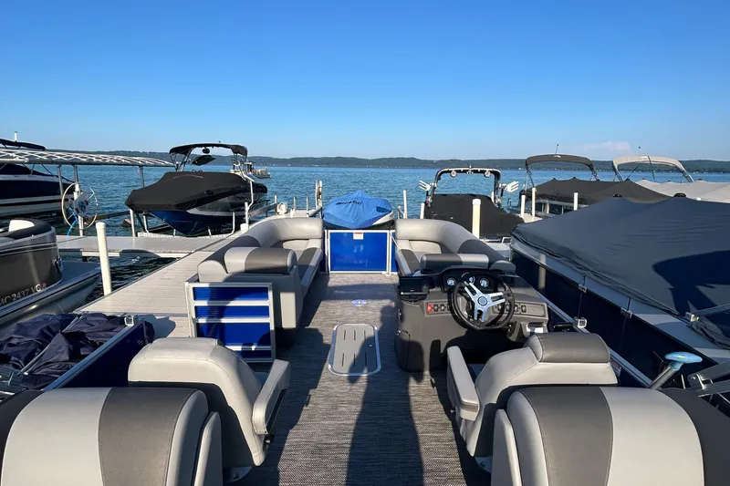 Slide: The Image of 2024 Bennington 22 SSR pontoon boat docked, featuring spacious seating and modern helm. - 4