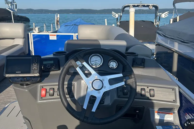 Slide: The Image of 2024 Bennington 22 SSR boat dashboard with steering wheel and navigation controls. - 6