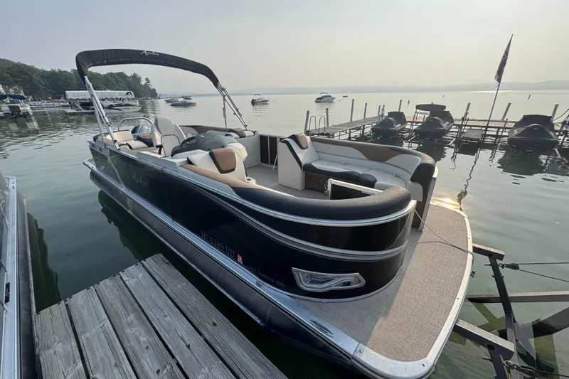 The Image of 2022 Avalon 22 Quad pontoon boat docked on a serene lake. - 2