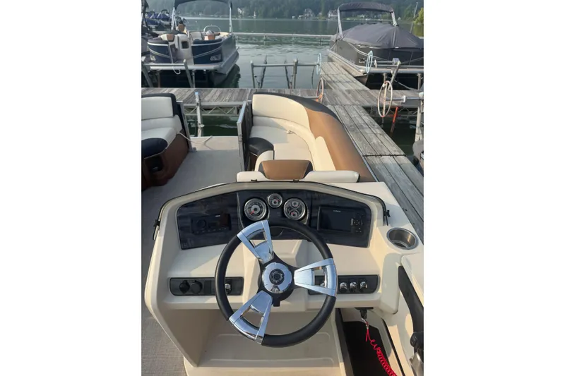 Slide: The Image of 2022 Avalon 22 Quad boat dashboard with steering wheel, docked at marina. - 4