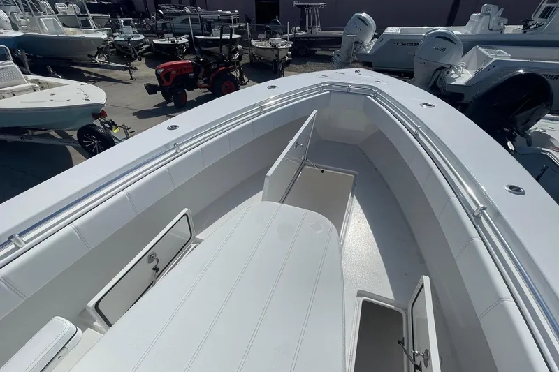 Slide: The Image of 2026 Contender 32 ST boat with open storage compartments, docked among other vessels. - 12