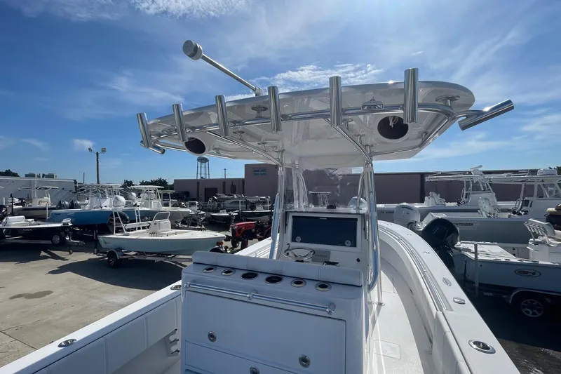 Slide: The Image of 2026 Contender 32 ST boat with T-top and rod holders in a marina setting. - 14