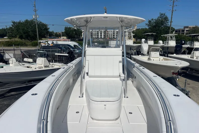 Slide: The Image of 2026 Contender 32 ST boat with center console, docked in a marina under clear blue skies. - 15