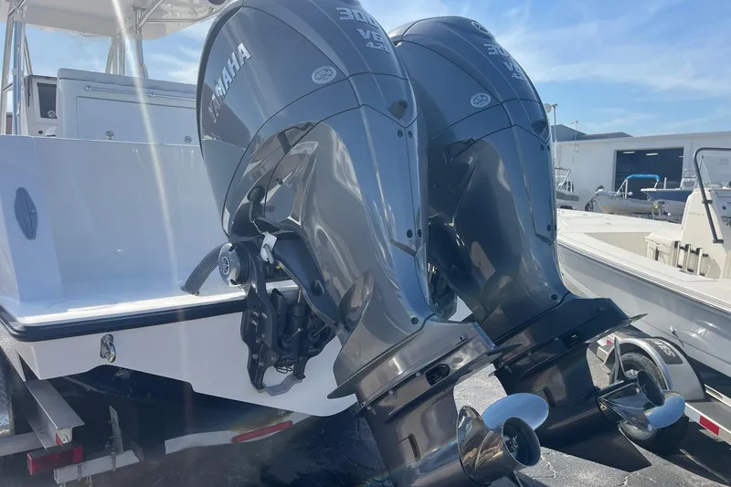 Slide: The Image of 2026 Contender 32 ST boat with dual Yamaha outboard engines, docked under clear skies. - 2
