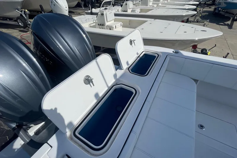 Slide: The Image of 2026 Contender 32 ST boat with open storage compartments and dual outboard engines. - 4