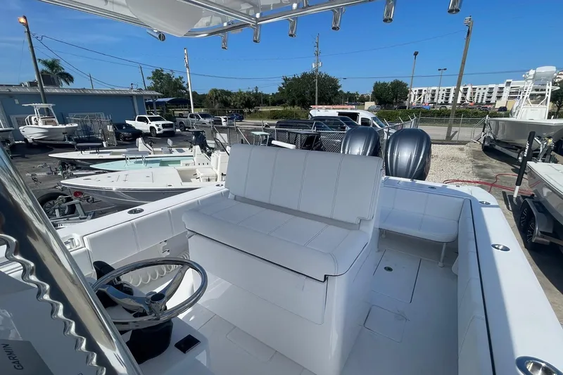 Slide: The Image of 2026 Contender 32 ST boat with dual engines, white seating, and steering wheel in a marina setting. - 8