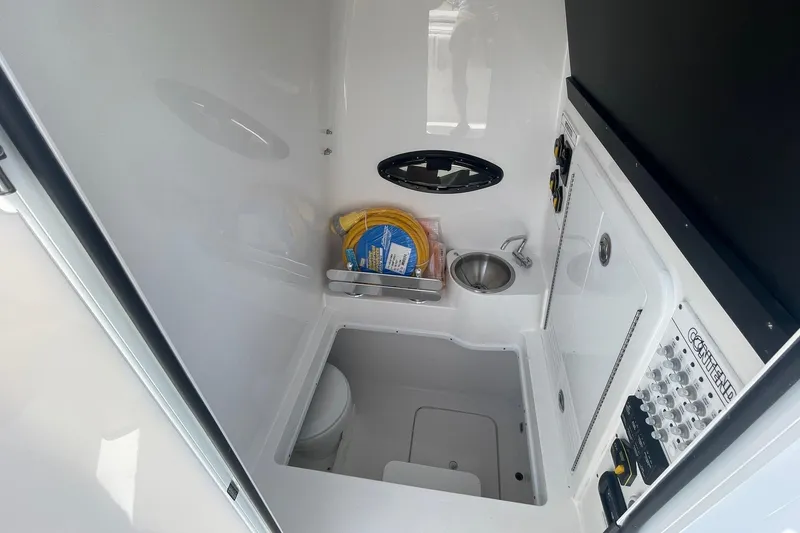 Slide: The Image of Interior of 2026 Contender 32 ST boat featuring compact bathroom with sink and storage. - 9