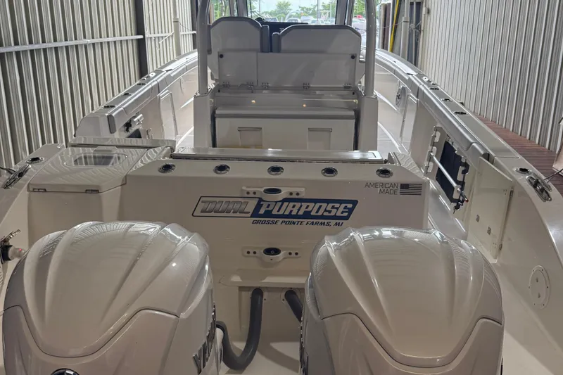 Slide: The Image of 2022 Pursuit S 328 Sport boat with dual engines in a storage facility. - 19