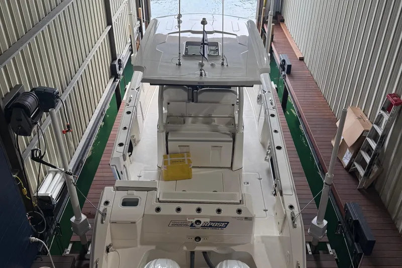 Slide: The Image of 2022 Pursuit S 328 Sport boat docked in a covered marina. - 20