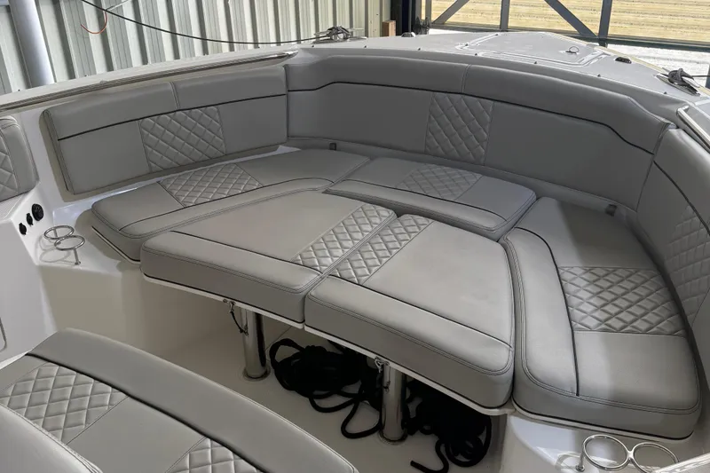 Slide: The Image of 2022 Pursuit S 328 Sport boat interior with gray cushioned seating and cup holders. - 5