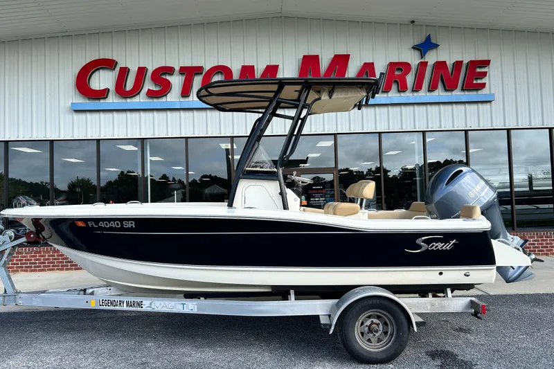 The Image of 2020 Scout 195 Sportfish boat on trailer outside Custom Marine dealership. - 1