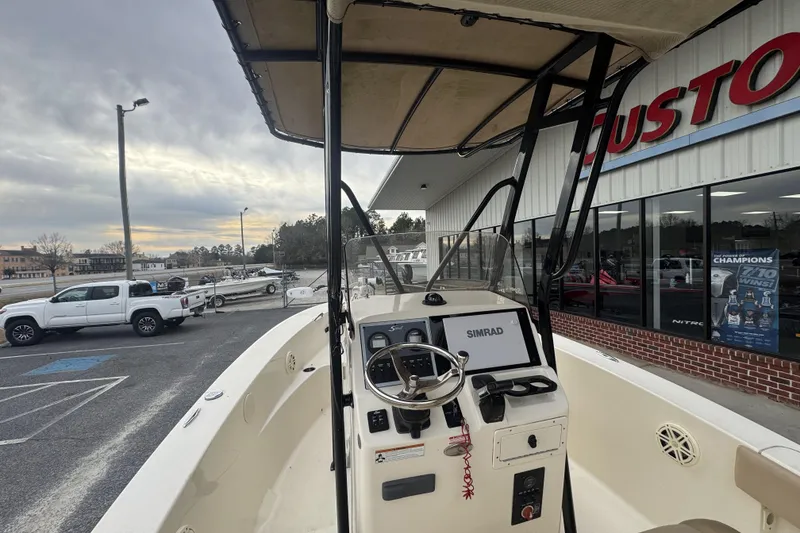 Slide: The Image of 2020 Scout 195 Sportfish boat with steering console, parked outside dealership. - 16