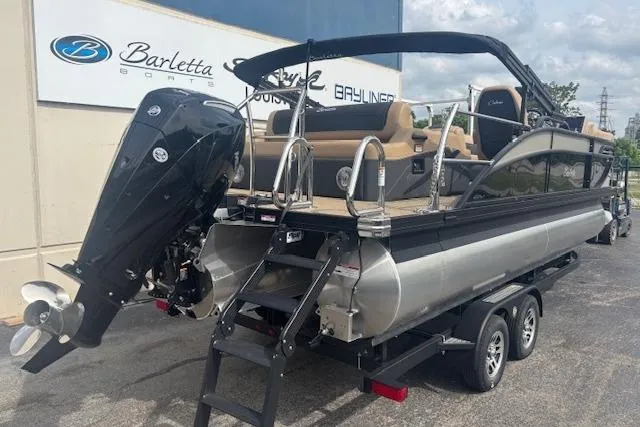 Slide: The Image of 2026 Barletta C22UC pontoon boat on trailer, featuring powerful outboard motor. - 2