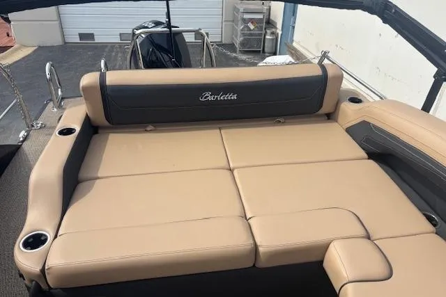 Slide: The Image of 2026 Barletta C22UC boat with tan and black seating, docked outdoors. - 9