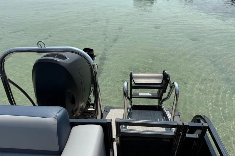 Slide: The Image of 2025 Avalon 25 LSZ Elite boat with motor and swim ladder on clear water. - 6