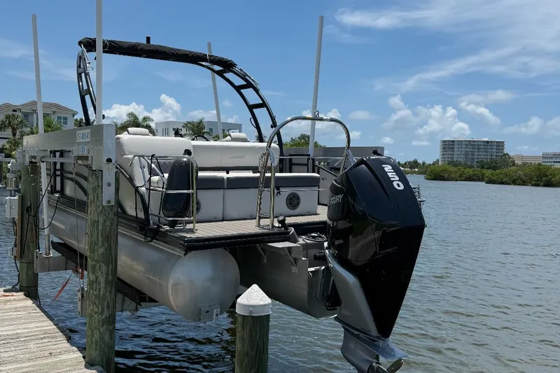 The Image of 2023 Harris Sunliner 230 pontoon boat docked by waterfront under clear sky. - 0