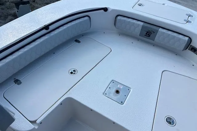 Slide: The Image of 2026 Carolina Skiff 24 Ultra Elite boat deck with storage compartments and cushioned seating. - 9