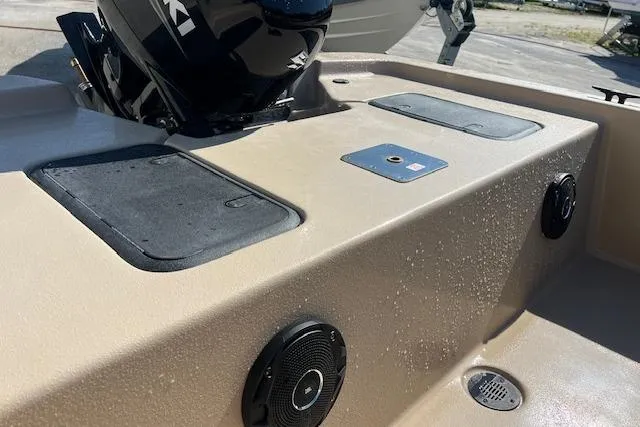 Slide: The Image of 2026 Carolina Skiff E18 JVX CC boat interior with storage compartments and speaker. - 2