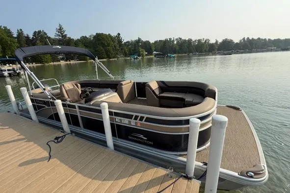The Image of 2023 Bennington 24 SSR pontoon boat docked on a serene lake. - 1