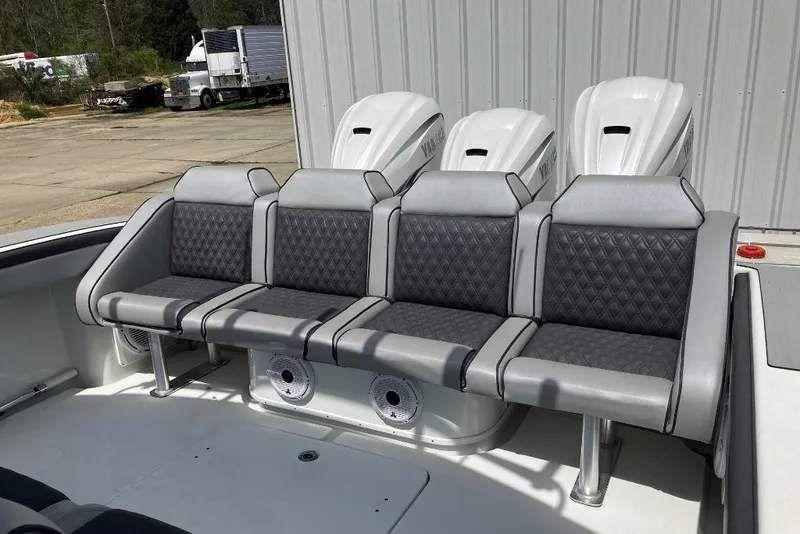 Slide: The Image of 2012 Yellowfin 42 Offshore boat with gray seating and triple outboard engines. - 11