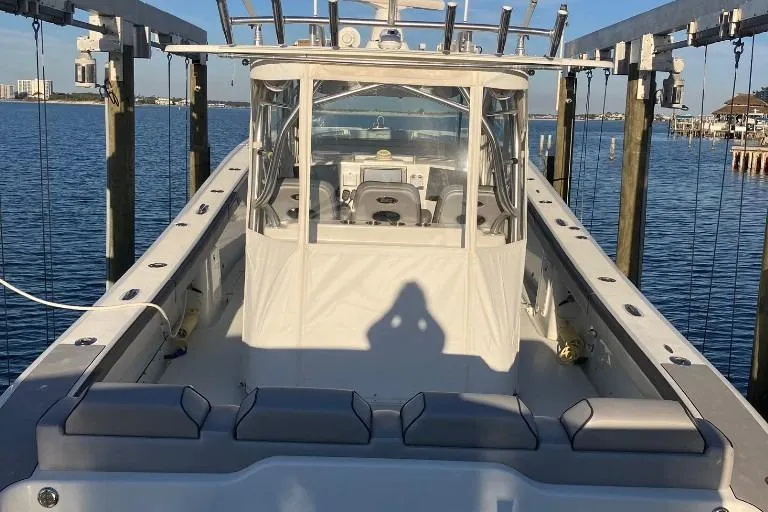 Slide: The Image of 2012 Yellowfin 42 Offshore boat docked, featuring spacious seating and modern design. - 19