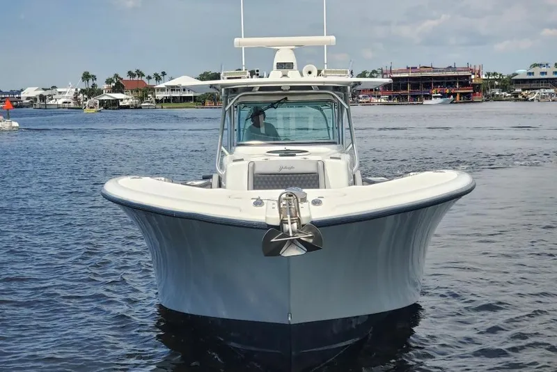 Slide: The Image of 2012 Yellowfin 42 Offshore boat on calm water, with coastal buildings in the background. - 3