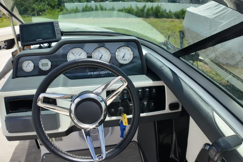 Slide: The Image of 2018 Regal 2300 Bowrider dashboard with steering wheel and gauges in sunlight. - 12