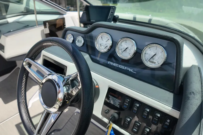 Slide: The Image of 2018 Regal 2300 Bowrider dashboard with steering wheel and gauges in sunlight. - 13