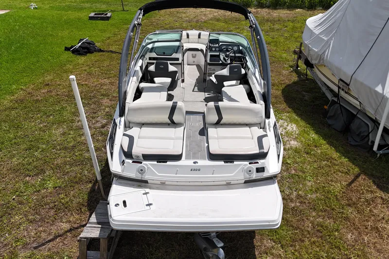 Slide: The Image of 2018 Regal 2300 Bowrider boat with spacious seating, parked on grass. - 2
