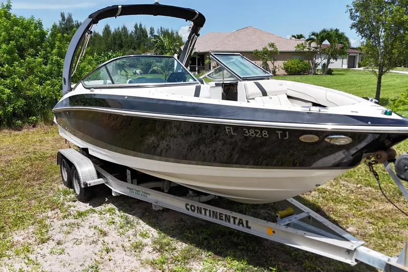 Slide: The Image of 2018 Regal 2300 Bowrider boat on trailer, parked outdoors in a residential area. - 6