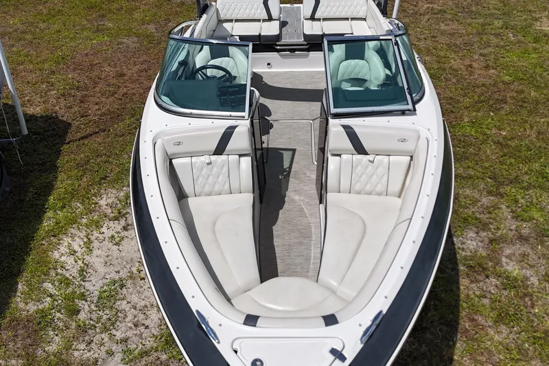 Slide: The Image of 2018 Regal 2300 Bowrider boat with spacious seating, viewed from above on grassy terrain. - 8