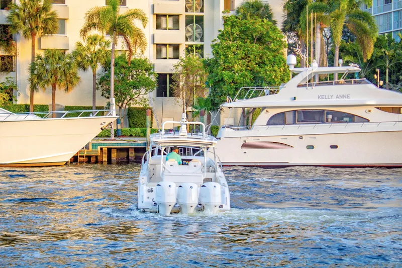 Slide: The Image of Everglades 360 LXC 2017 boat cruising near luxury yachts and waterfront buildings. - 2