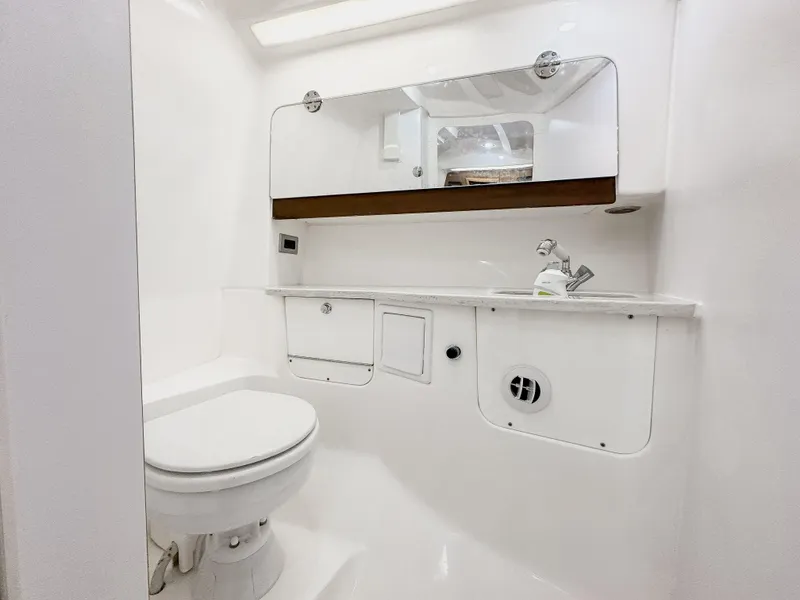 Slide: The Image of 2017 Everglades 360 LXC boat bathroom with white fixtures and storage. - 27